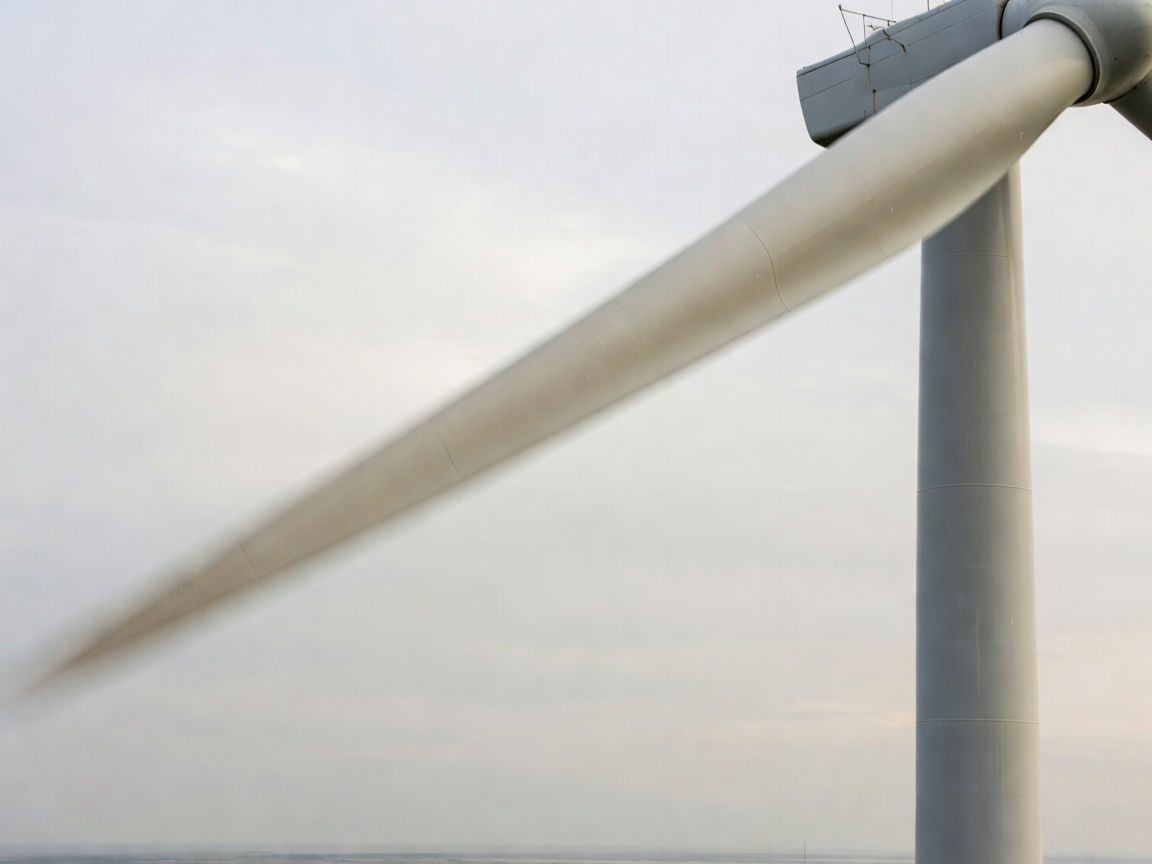 Close up of a wind turbine blade sweeping past the tower